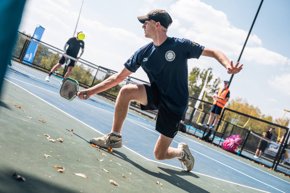 Kian van Rooyen stretching for a forehand during a match.