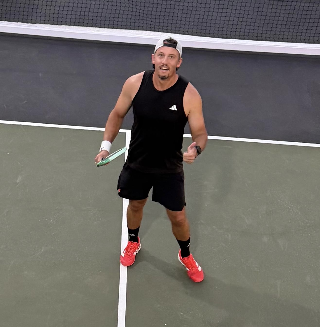 Norman Phillips on court, paddle in hand.